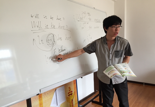 志愿者为小学生辅导英语